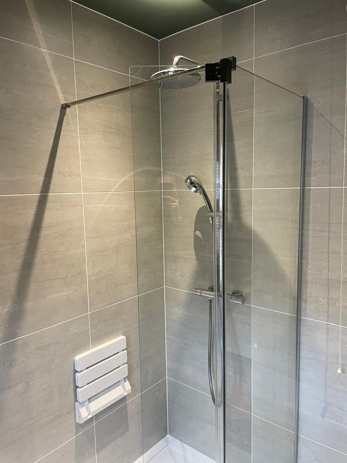 Modern shower room with glass screen and tiled walls