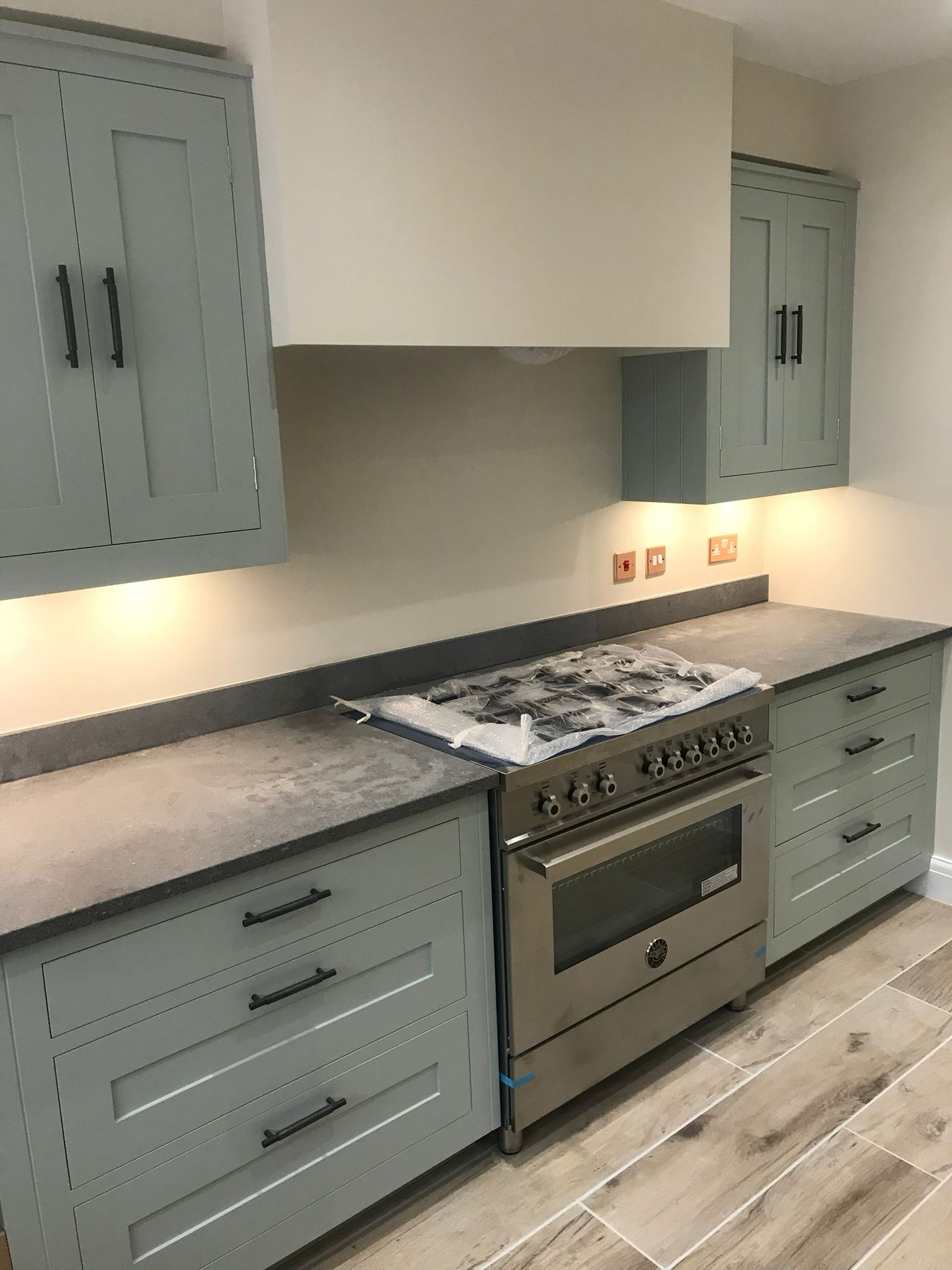 Modern grey fitted kitchen with lighting and worktops